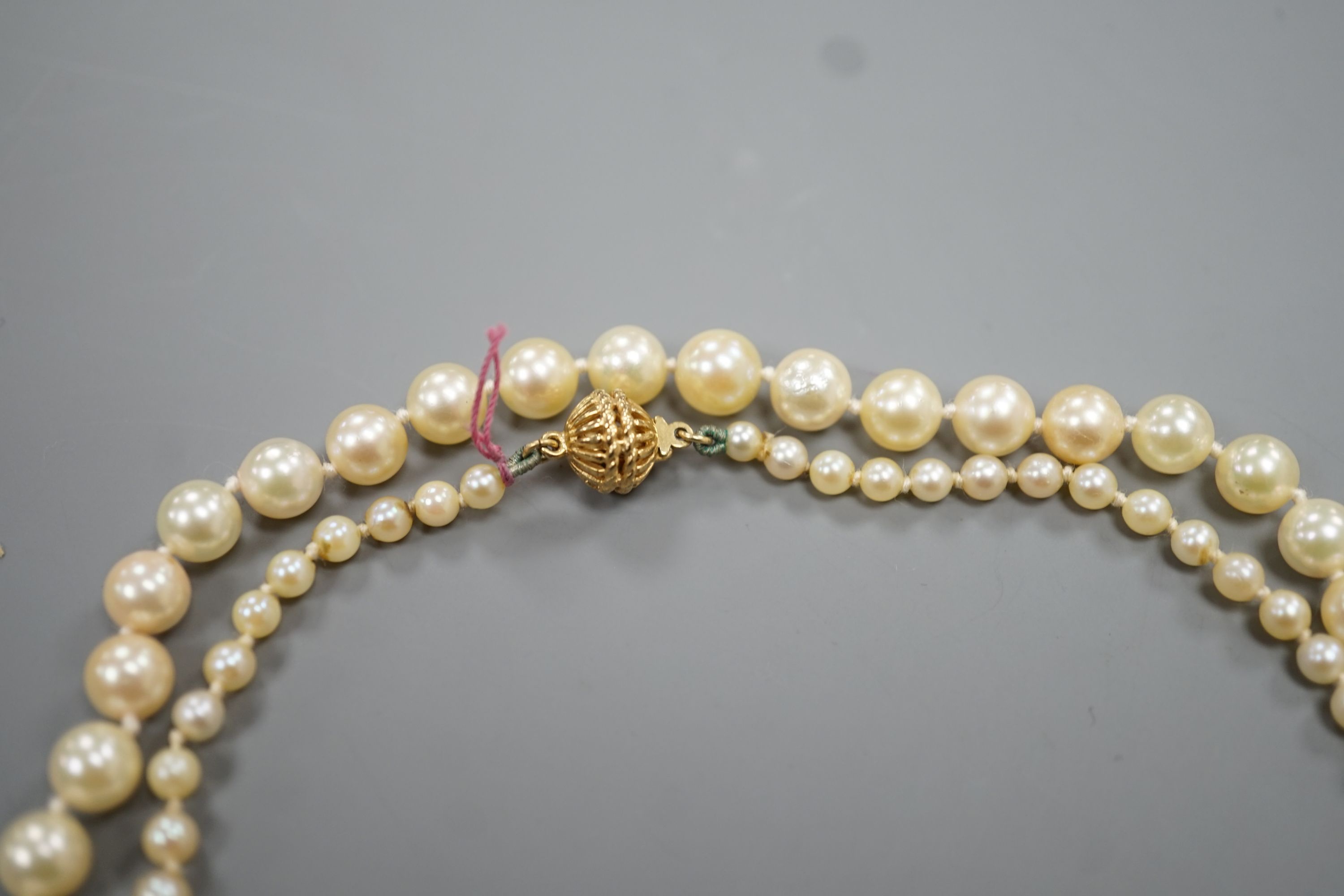 A singe strand graduated cultured pearl necklace with yellow metal clasp, 64cm, gross weight 20.3 grams.